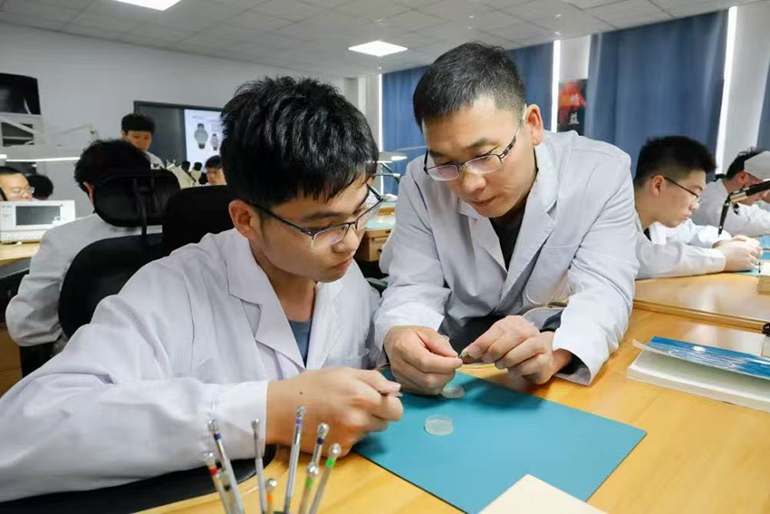 师生共同分析已装配完成的计时机芯工作状态。天津现代职业技术学院供图